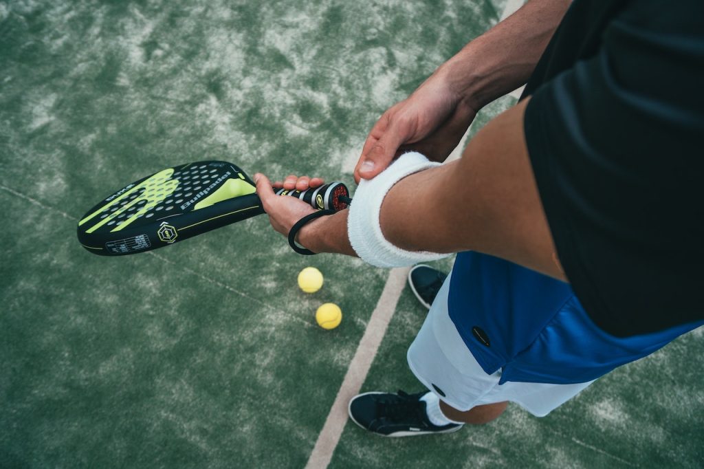 man gripping arm while playing tennis
